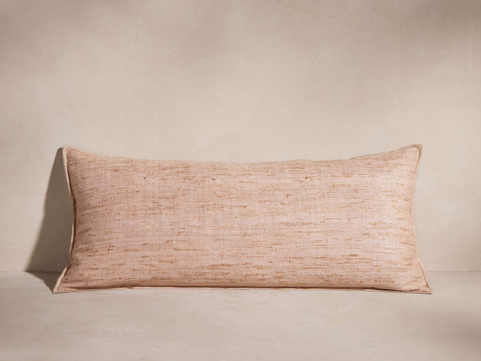 Rectangular Raw Silk Pillow in blush pink with textured, hand-woven fabric and merrow stitch edges, lying flat.