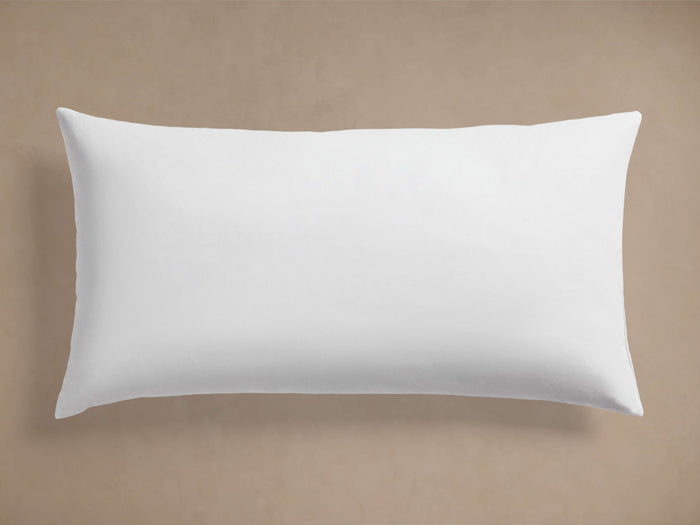 White rectangular Decorative Lumbar Pillow Insert, plump and smooth, centered horizontally on a plain beige background.