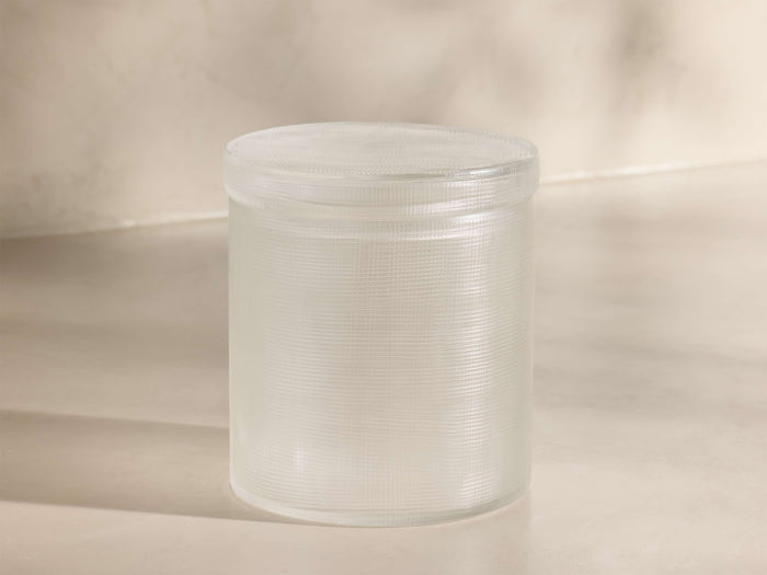 Front view of a translucent, cylindrical storage container with a ribbed texture and a flat, fitted lid.