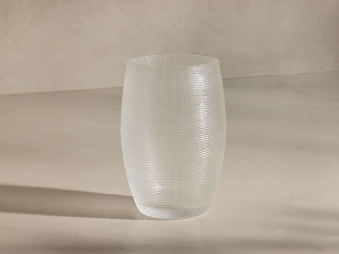 Frosted clear vase with subtle horizontal and vertical lines creating a delicate grid pattern, standing upright.