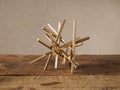 Metallic gold Abstract Bar Sculpture with intertwined, hand-hammered wrought iron bars on rustic wood.
