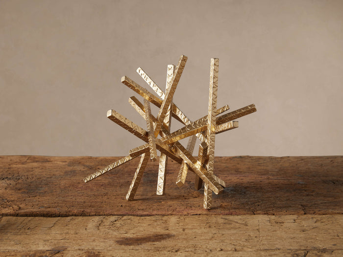 Metallic gold Abstract Bar Sculpture with intertwined, hand-hammered wrought iron bars on rustic wood.