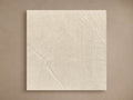 Square Alesso Outdoor Finish Board in light grey stone, showing subtle textured variations, leaning on a neutral brown wall.