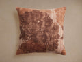 Amanda Pillow: Square linen pillow with a large brown floral print on a rustic beige background, standing upright.