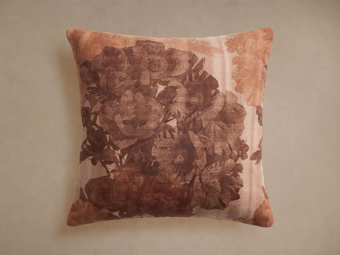 Amanda Pillow: Square linen pillow with a large brown floral print on a rustic beige background, standing upright.