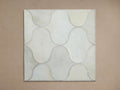 Amberly Rug Swatch: Square hair-on-hide sample with stitched, interlocking wavy cream and light grey shapes, laid flat.