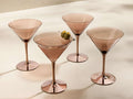 Front view of four rose gold Ambretta Martini Glasses, one holding a drink garnished with two green olives.