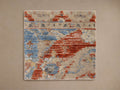 Square area rug with intricate red, blue, and beige patterns, featuring geometric and abstract designs on a neutral background.