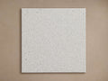 Apex Outdoor Dining Top Finish Board, a square light gray finish sample with speckled texture, on a light brown background.
