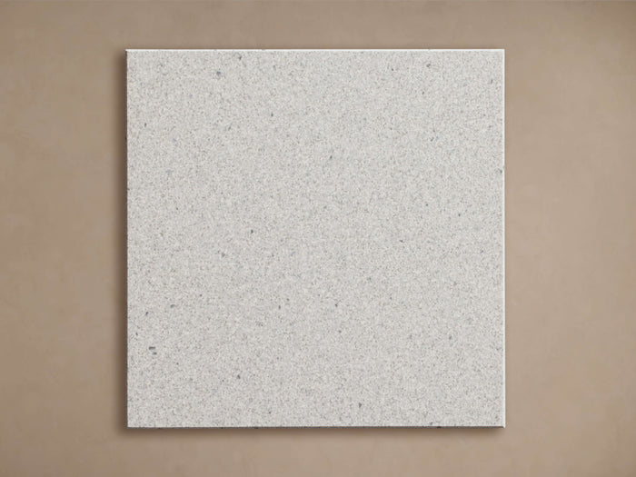 Apex Outdoor Dining Top Finish Board, a square light gray finish sample with speckled texture, on a light brown background.