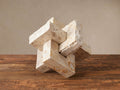 Aphra Abstract Sculpture: geometric interlocking blocks of natural, rough-edged beige and ivory mottled marble on a wooden surface.