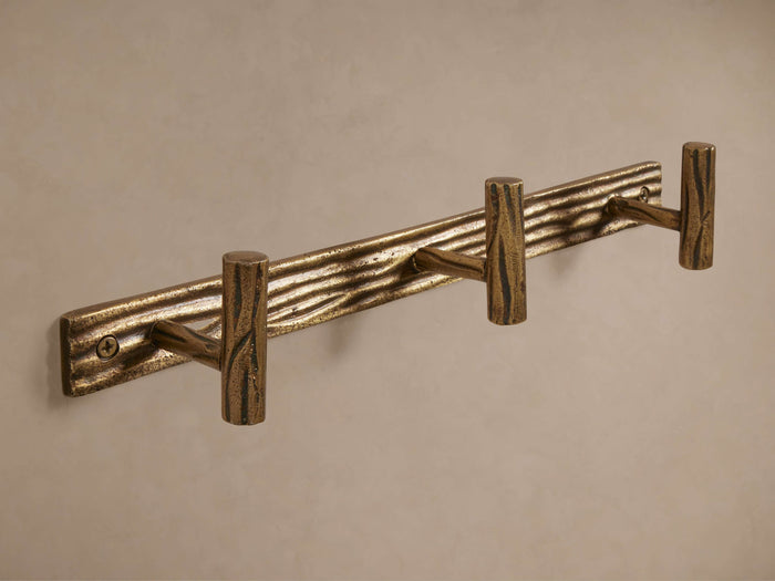 Arren Triple Hook: Textured brass-finish cast aluminum, with a bark-like backplate and three T-shaped hooks, mounted horizontally.