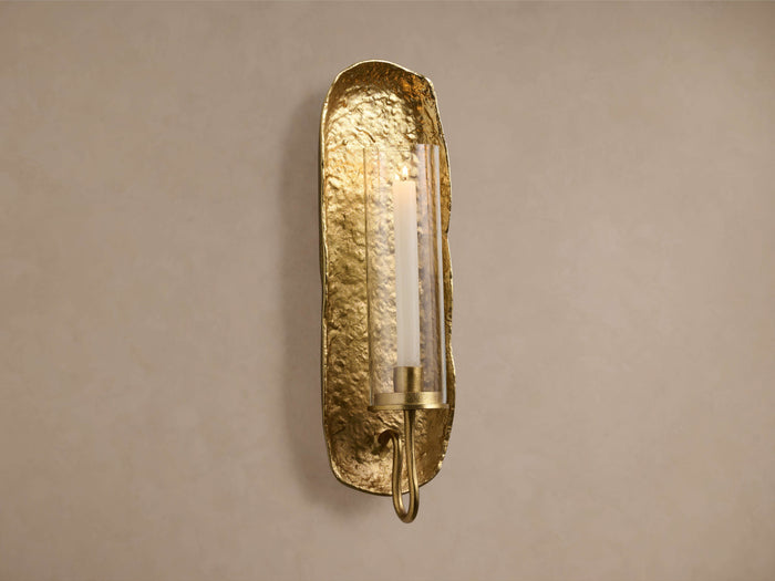 Artemis Wall Taper Candle Holder: Vertical, textured brass sconce with irregular edges, glass cloche, and white taper candle.