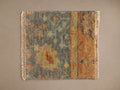 Aspyn Rug Swatch featuring a vintage pattern with blue, orange, yellow hues, and fringe on the sides against a neutral background.