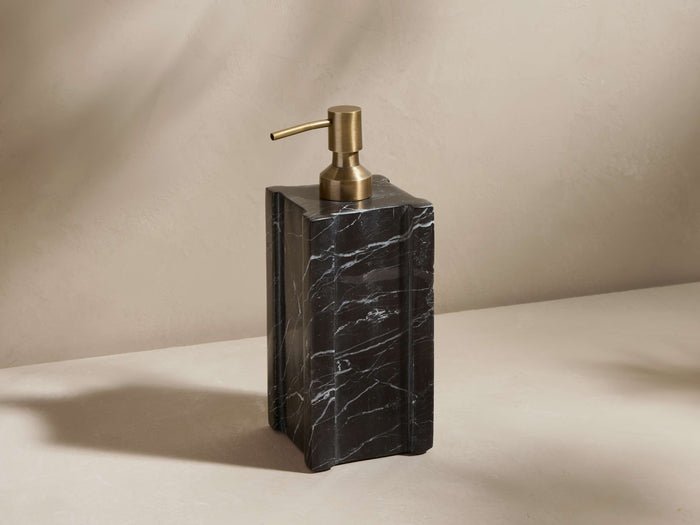 A black marble soap dispenser with natural veining, gold metal pump, and a rectangular shape on a neutral background.