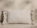 Front view of the cream mélange Audie Pillow, handwoven from merino wool with a basketweave texture and soft fringe on the ends.