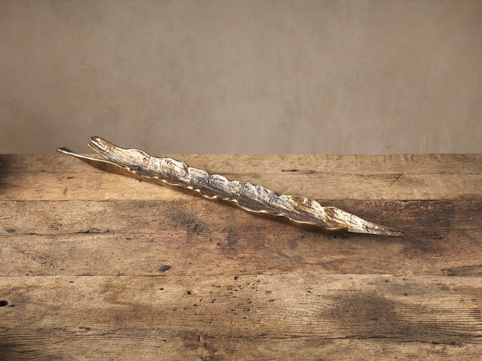Elongated Bark Texture Centerpiece Tray, dark antiqued brass with ridged surface, on a rustic wood table.