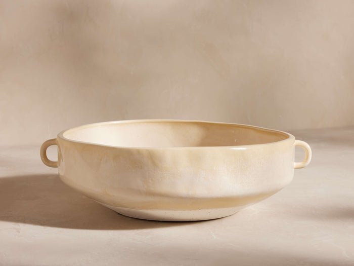 Bronwen Low Pot: Wide, low ceramic pot with two loop handles, glazed creamy yellow, handcrafted texture on a light background.