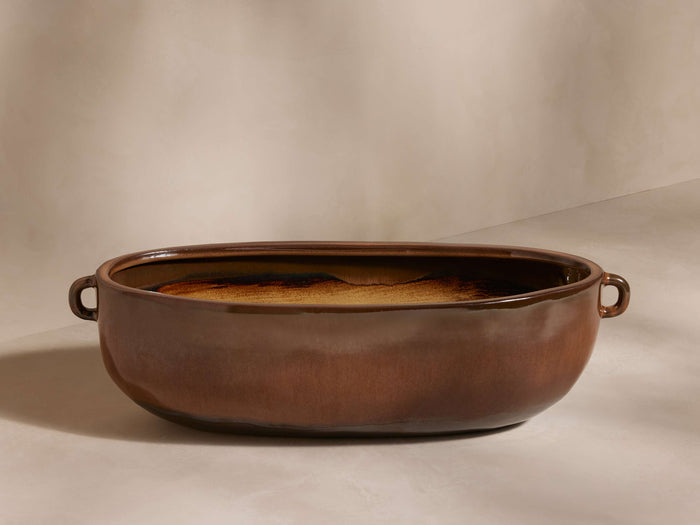 Bronwen Trough Planter in warm brown glaze, oval shape, with two side handles on a light background.