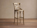 Cadence Stool, natural weathered oak with X-back and curved legs, light brown handwoven rattan seat, on wood floor.