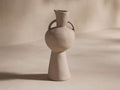 Calixta Vase in light taupe, featuring a matte finish. Vase has a wide, rounded body with two loop handles and a narrow neck.
