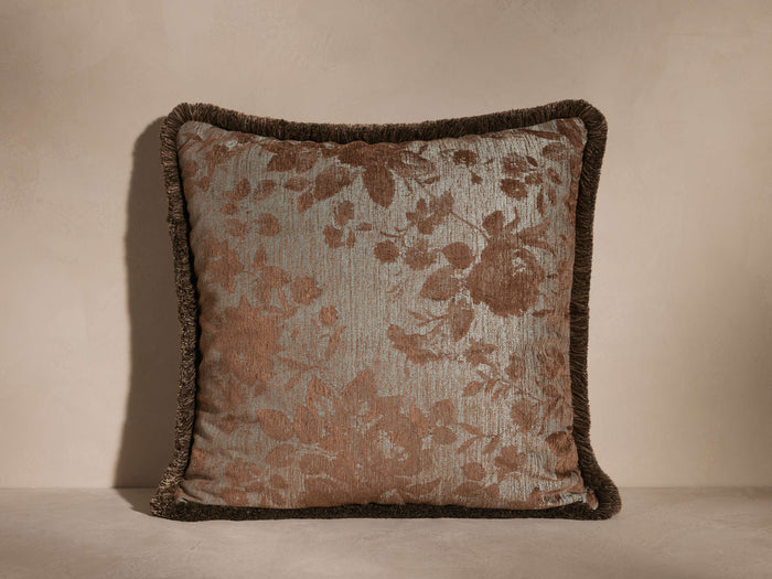 Camellia Fringe Pillow with a woven jacquard floral motif in neutral hues, featuring a coordinating fringe edge, on a plain surface.
