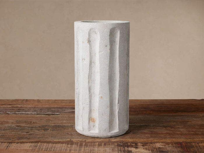 Light grey Cantera Vase, tall & cylindrical, with vertical hand-carved grooves, on rustic wood table.