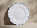 Capuchos Dinner Plate; white, hand-thrown ceramic with matte glaze, ruffled rim, and hand-painted blue edging.