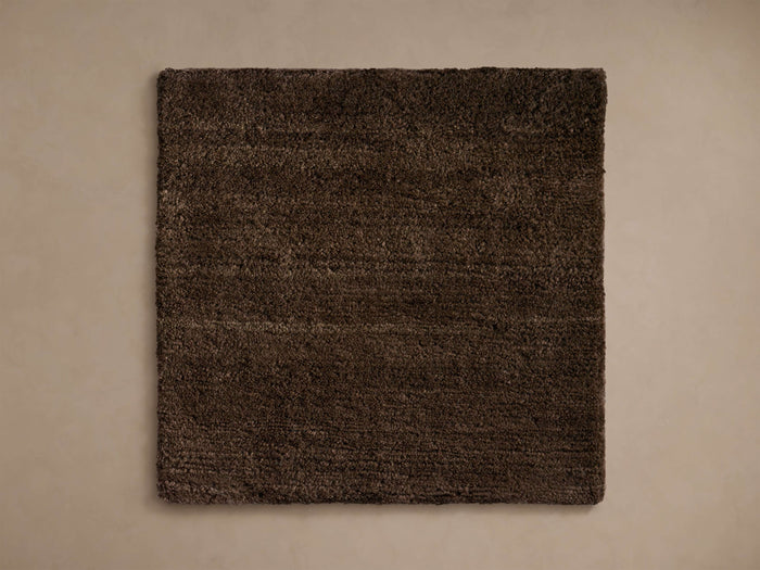 Square cashmere blend rug swatch in a deep brown shade with a soft texture, placed on a light-colored background.
