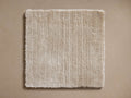 Cashmere Handwoven Rug Swatch in a square shape, featuring a soft beige color and a textured, plush surface on a tan background.
