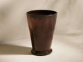Cassia Vase, a tall, dark brown hand-blown recycled glass vase with a subtle taper and rounded base, standing on a light surface.