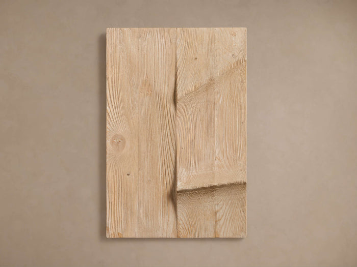 Cassian Carving: a light natural-colored wooden rectangular panel with an organic, wavy vertical carving on a neutral wall.