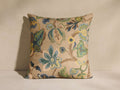 Cecillo Pillow with vibrant floral & vine pattern in blues, greens, yellows, & brown on a textured beige background.