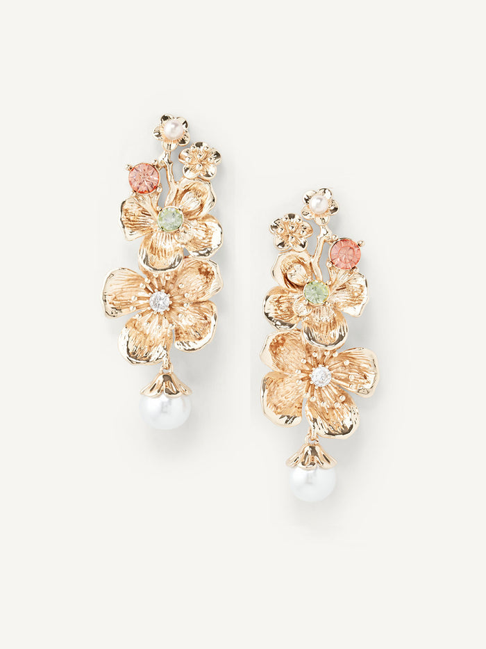 Gold floral earrings with pearls on a white background