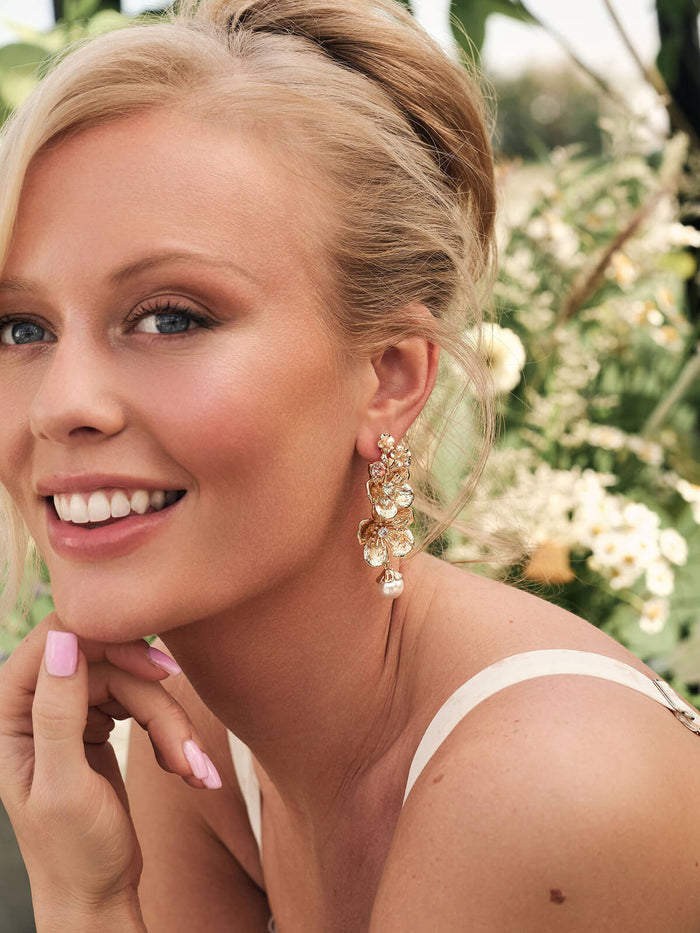 Woman wearing elegant earrings with a blurred natural background