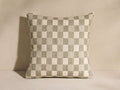 Square Check Pillow with a sage green and cream woven checkerboard pattern, standing upright against a light wall.