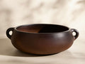 Front view of the chocolate-brown Chulucanas Low Bowl, a smooth, wide bowl with two small, rounded handles.