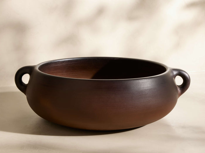 Front view of the chocolate-brown Chulucanas Low Bowl, a smooth, wide bowl with two small, rounded handles.