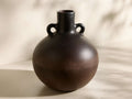 Front view of a spherical Chulucanas Low Bowl in dark chocolate-brown, with two handles and a subtle burnished sheen.