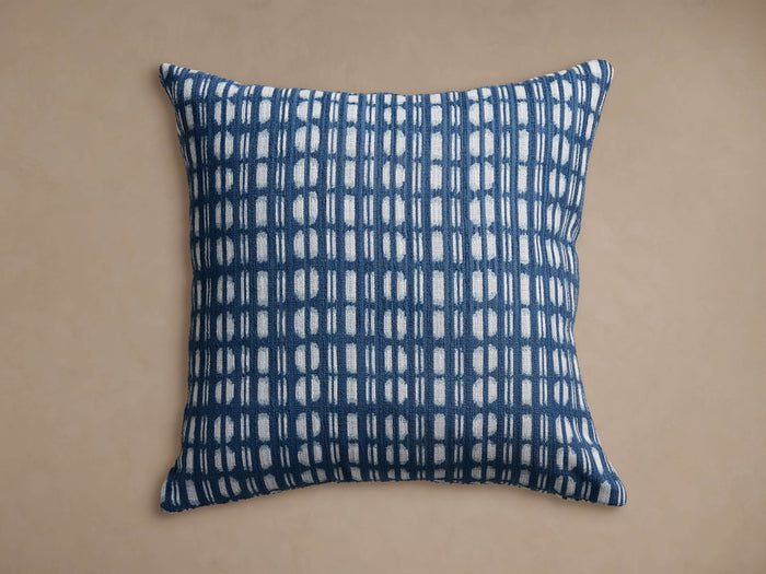 Square Cielos Outdoor Pillow in navy blue & white, geometric grid pattern of vertical lines & stacked half-circles, knife-edge.