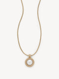 A gold snake chain necklace with a circular pendant featuring a white pearl in the center, set against a clean off-white background.