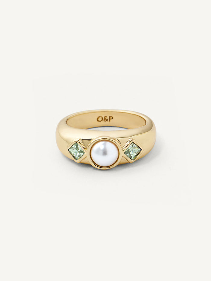 Gold ring with a pearl and green gemstones on a white background