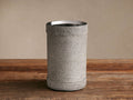 Colette Wine Chiller, cylindrical, wrapped in light gray hair-on-hide with visible stitching, silver stainless steel rim, on wood.