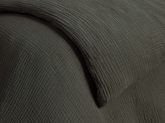 Close-up of a dark green Cotton Gauze Duvet, showcasing its soft, crinkled texture and gentle folds.