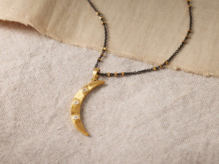 Crescent Moonstone Necklace with gold vermeil crescent-shaped pendant featuring moonstones, on an oxidized silver chain.