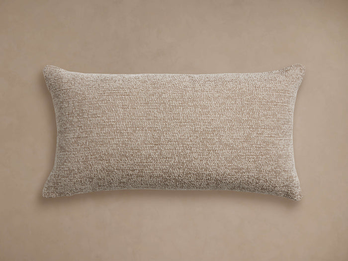 Dani Outdoor Lumbar Pillow, horizontal, light brown textured woven fabric, centered on a neutral beige background.