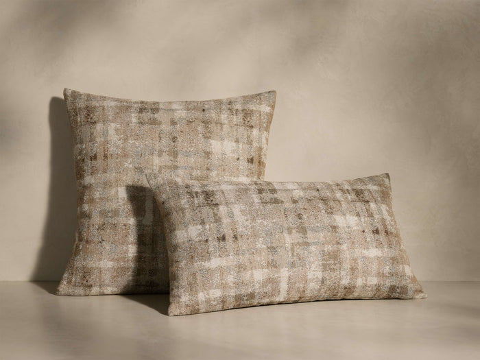 Front view of two Daraja Pillows, one square and one rectangular, featuring a distressed plaid pattern in beige, brown, and cream.
