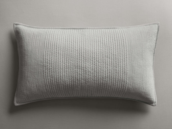 Rectangular light gray Daria Velvet Sham, with fine vertical quilted stitching and corded piping, lying flat.