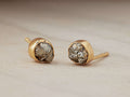 Darian Pyrite Bezel Stud Earrings with irregular pyrite nuggets set in gold-plated sterling silver, placed on a soft surface.