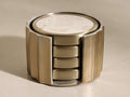 Angled view of Dayana Coasters (Set of 4) in a brass fluted holder with cream natural marble stone inlays.